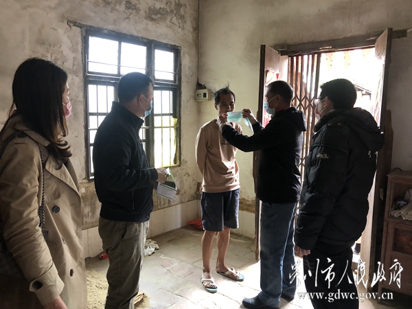 梅岭社区干部给精准扶贫户何振福戴上口罩。2045.jpg